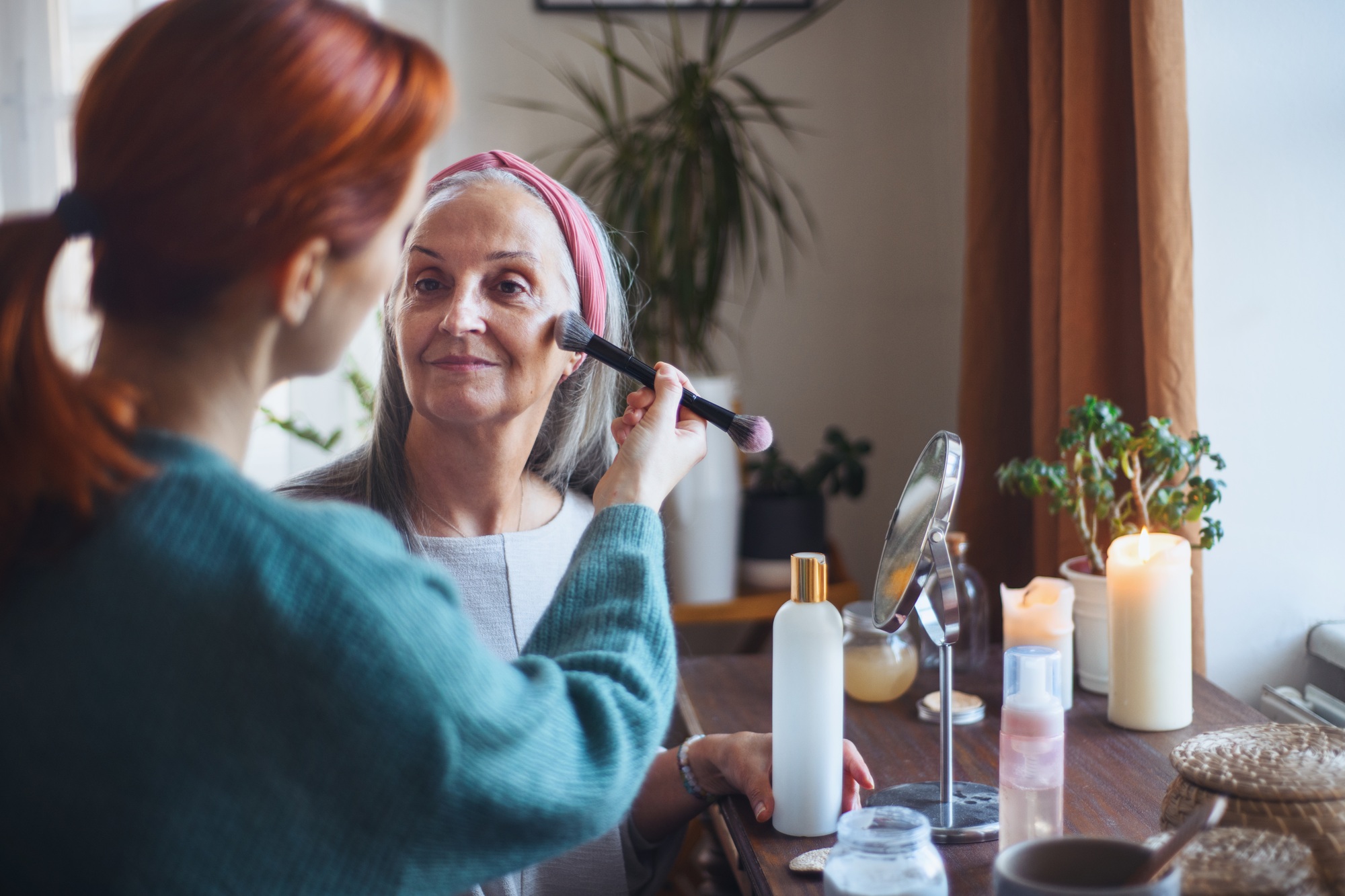 Caregiver helping her client with a make up.